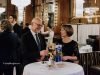 Event Photography Prices in Berlin: How a Quote Is Built Two guests in evening dress talking beside a branded table at a reception