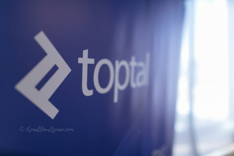 Brand banner photographed as a detail at a launch event, logo in sharp focus